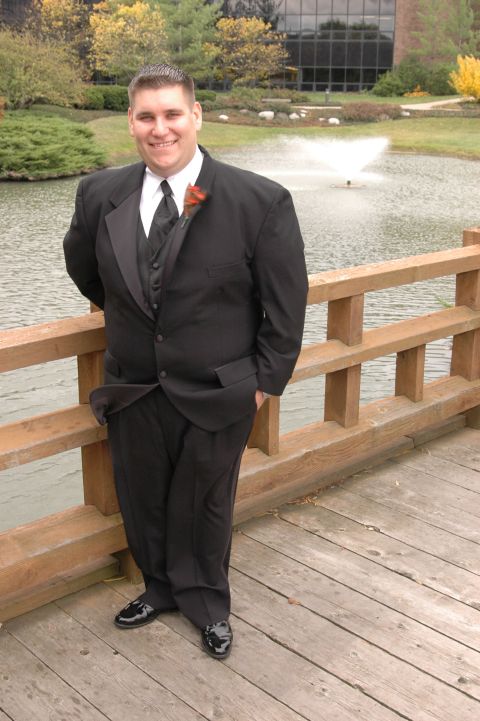 1985 Ford Crown Victoria LTD - Man in formal wear poses on a wooden bridge with a pond and fountain in the background.