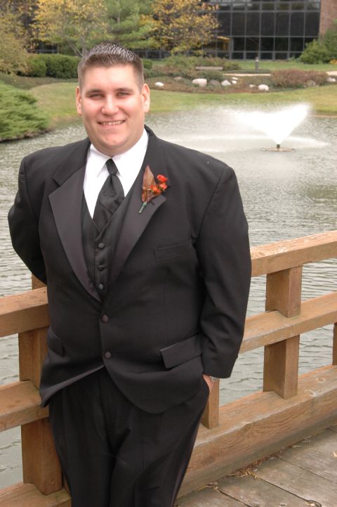 1985 Ford Crown Victoria LTD - A man in a tuxedo poses for a photo near a body of water with a fountain.