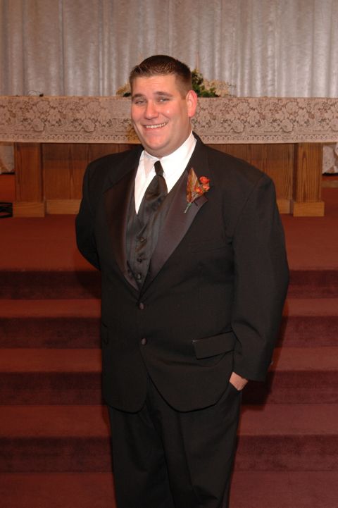 1985 Ford Crown Victoria LTD - A groom poses for a photo in front of the altar at a wedding ceremony.