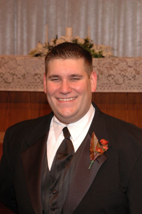 1985 Ford Crown Victoria LTD - Man in tuxedo smiles for the camera, wearing a boutonniere on his lapel.