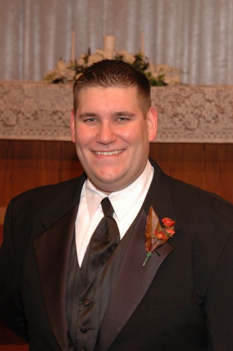 1985 Ford Crown Victoria LTD - A man in a tuxedo smiles for the camera, with a boutonniere on his lapel.