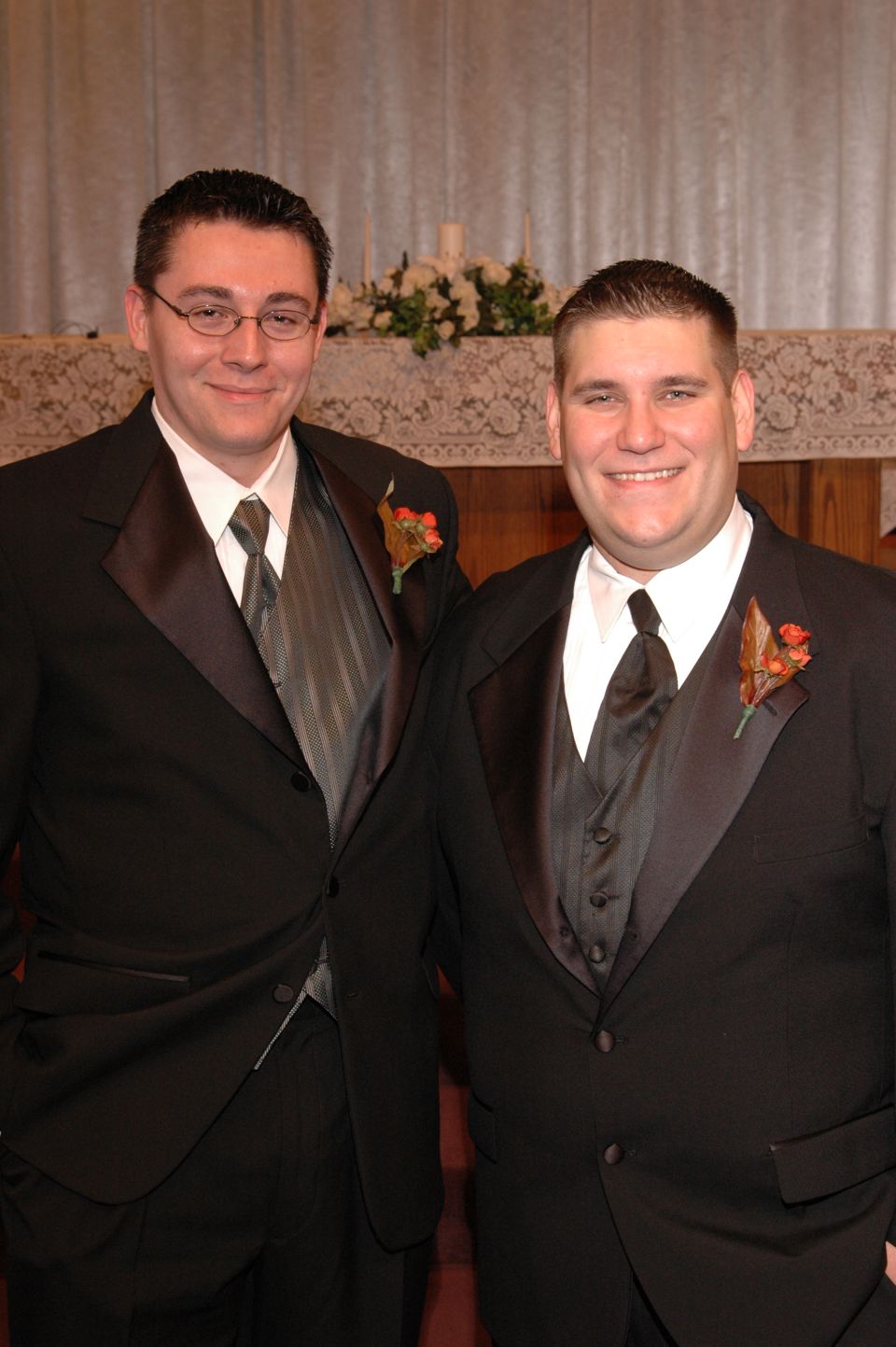 Two men in tuxedos stand side-by-side