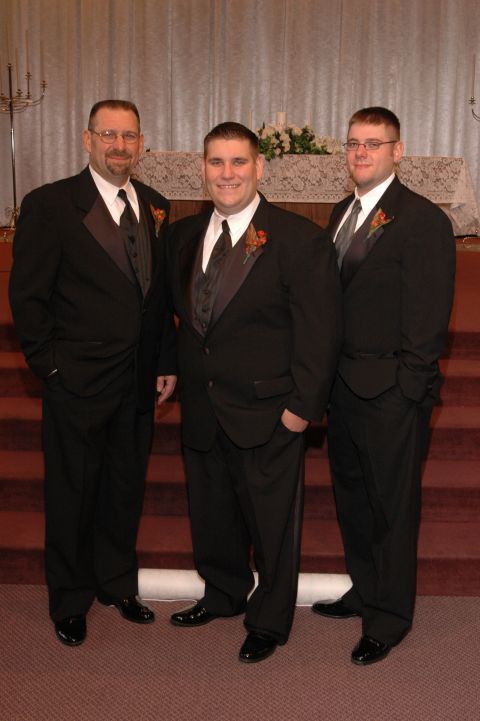 1985 Ford Crown Victoria LTD - Three groomsmen pose for a photo in front of a church altar.
