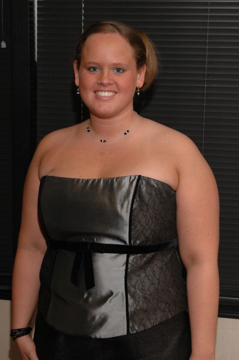 1985 Ford Crown Victoria LTD - A woman poses for a photo while wearing a strapless grey dress with black lace details and a velvet ribbon sash.