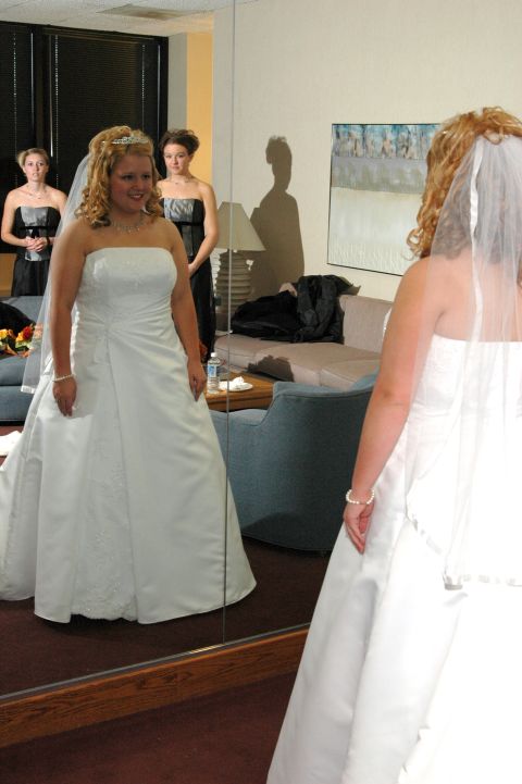 1985 Ford Crown Victoria LTD - A bride and her bridesmaids prepare for the wedding ceremony in a room with a large mirror.