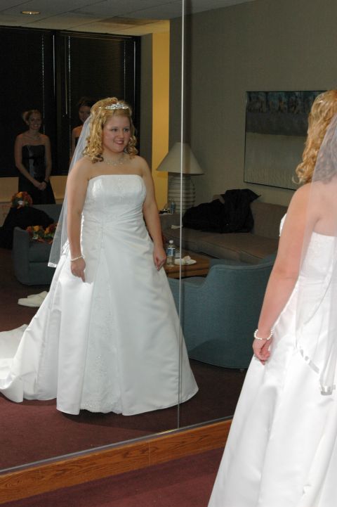 1985 Ford Crown Victoria LTD - A bride admires herself in a mirror, with bridesmaids visible in the reflection.