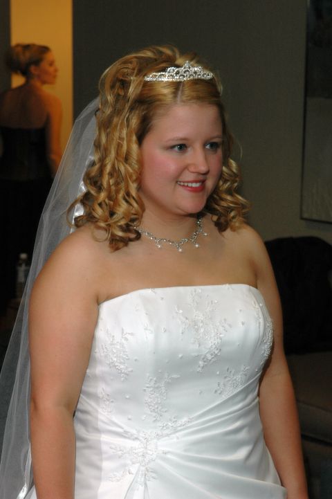 1985 Ford Crown Victoria LTD - A bride smiles, wearing a white strapless wedding dress and a tiara, with a veil.