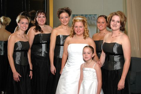 1985 Ford Crown Victoria LTD - A bride poses with her bridesmaids and a flower girl, all dressed for a wedding ceremony.