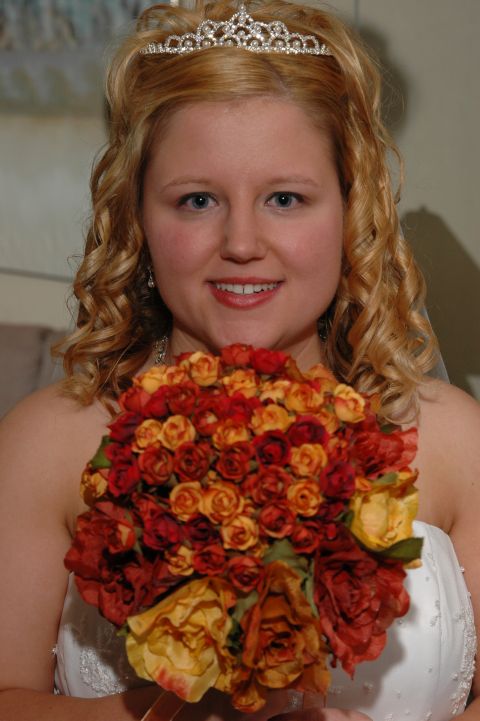 1985 Ford Crown Victoria LTD - A bride poses for a photo while holding a colorful bouquet of roses.