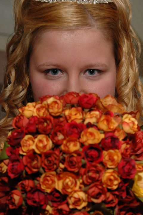 1985 Ford Crown Victoria LTD - A bride holds a bouquet of roses, her eyes visible above the flowers.