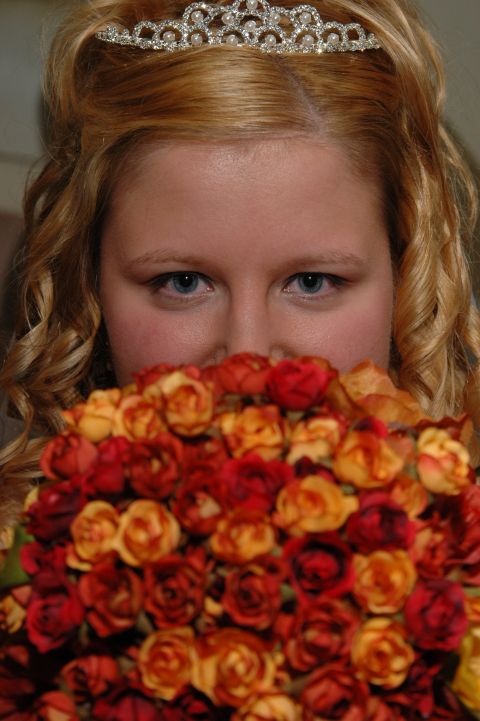1985 Ford Crown Victoria LTD - A bride holds a bouquet of roses, her tiara visible above the flowers.