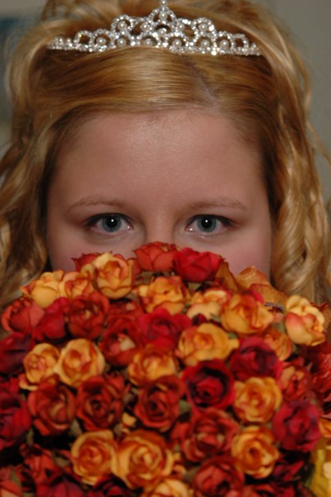1985 Ford Crown Victoria LTD - A bride wearing a tiara peeks over a bouquet of roses, her eyes visible above the flowers.