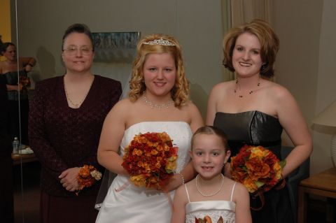 1985 Ford Crown Victoria LTD - A bride, bridesmaids, and a flower girl pose for a wedding photo.