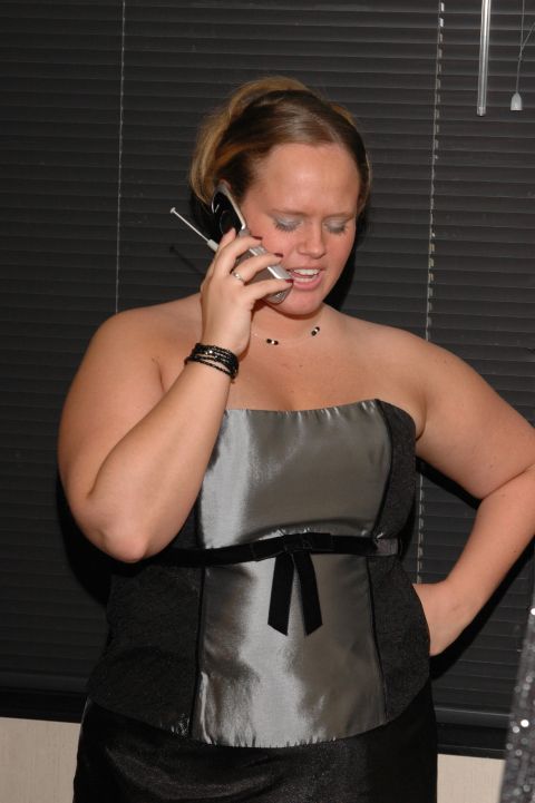1985 Ford Crown Victoria LTD - A woman is seen talking on a flip phone while wearing a strapless dress.
