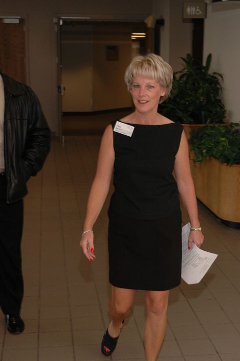 1985 Ford Crown Victoria LTD - A woman wearing a black dress and a man in a leather jacket walk down an indoor hallway.