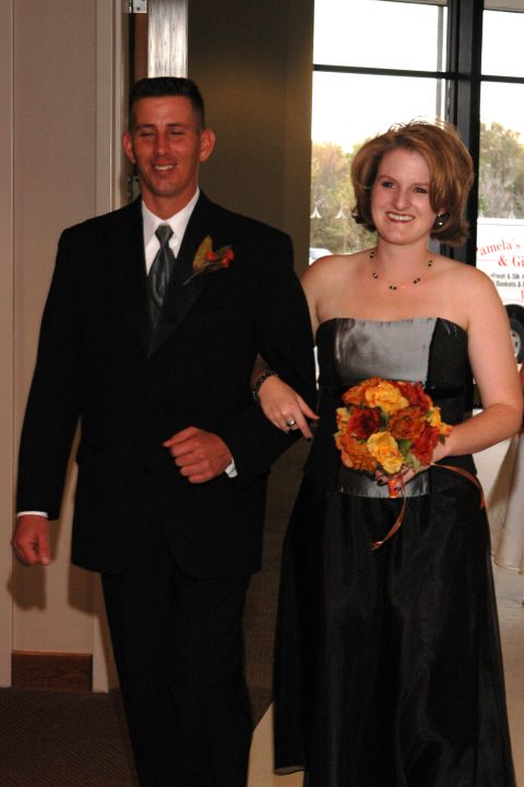 1985 Ford Crown Victoria LTD - A man and woman in formal attire walk arm-in-arm, possibly at a wedding or formal event.