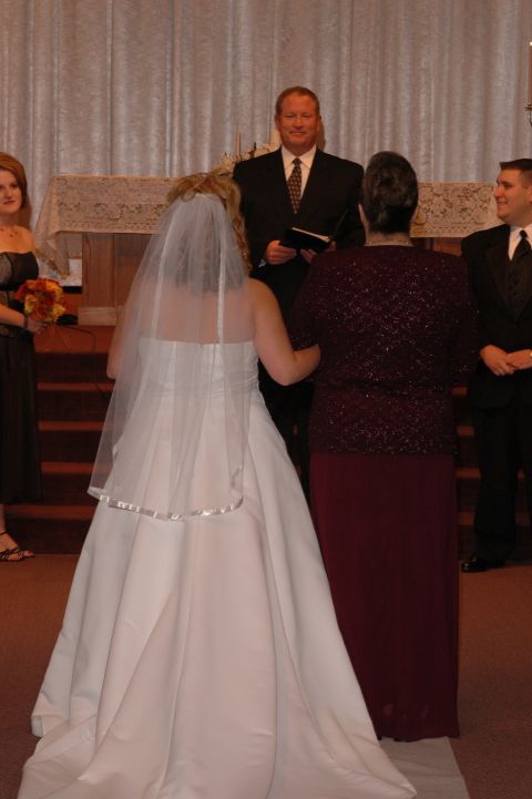 1985 Ford Crown Victoria LTD - A wedding ceremony is taking place with the bride and groom at the altar.