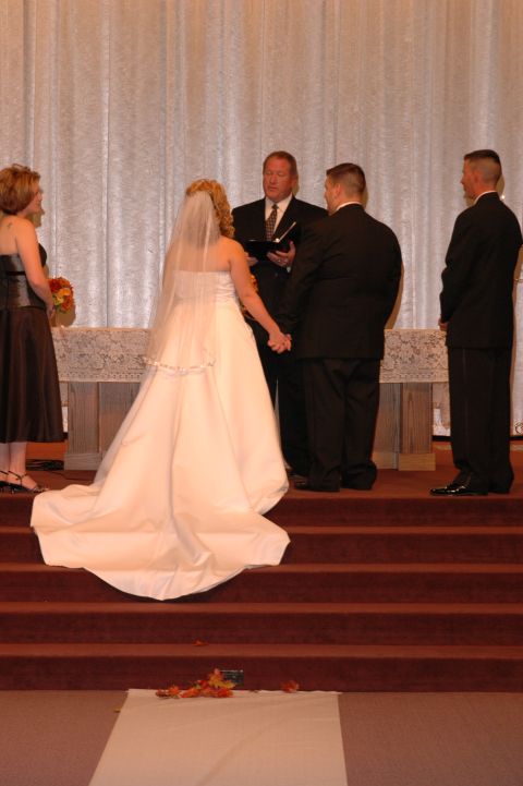 1985 Ford Crown Victoria LTD - A wedding ceremony is taking place with the bride and groom holding hands at the altar.