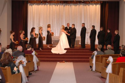 1985 Ford Crown Victoria LTD - A wedding ceremony takes place with guests seated in pews.