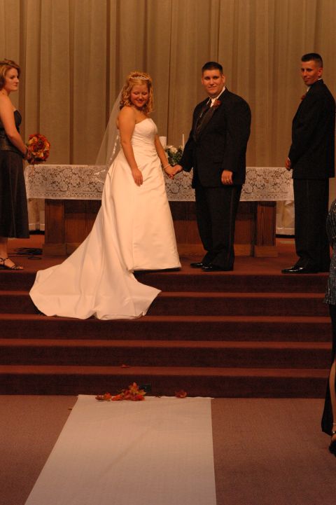 1985 Ford Crown Victoria LTD - A wedding ceremony takes place with the bride and groom holding hands at the altar.