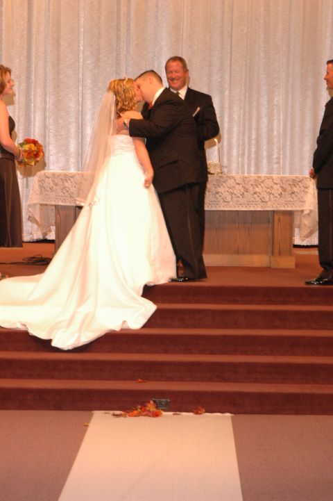 1985 Ford Crown Victoria LTD - A wedding ceremony is taking place with the bride and groom sharing a kiss at the altar.