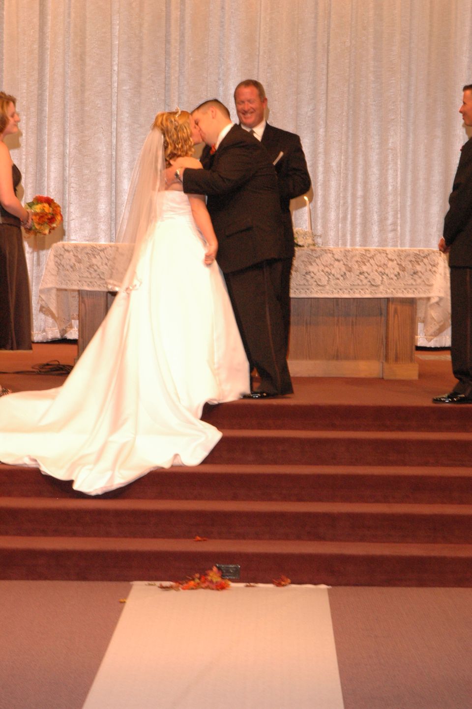 Wedding ceremony with bride and groom kissing at the altar