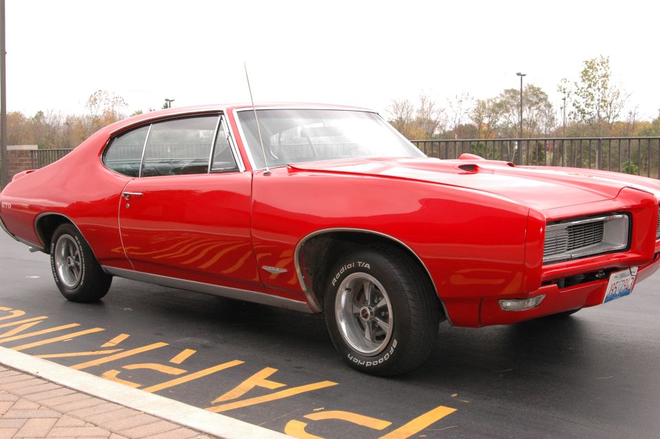 Red 1969 Pontiac GTO coupe parked on asphalt