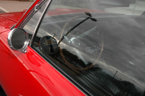 1985 Ford Crown Victoria LTD - Interior view of a red car, showing the steering wheel and dashboard reflected in the windshield.