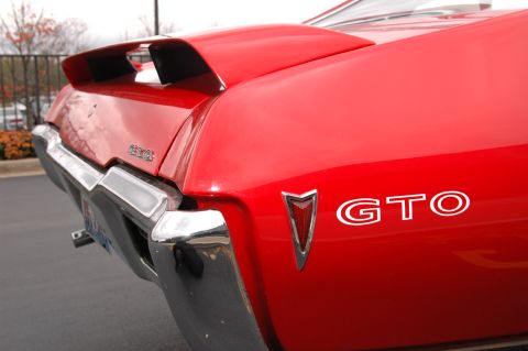 1985 Ford Crown Victoria LTD - Rear view of a red car with a GTO badge and chrome bumper.