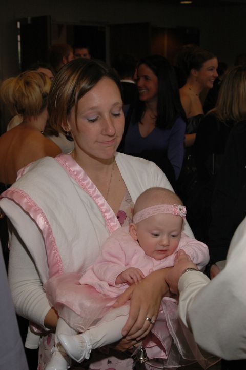 1985 Ford Crown Victoria LTD - A woman holds a baby dressed in pink at an event.