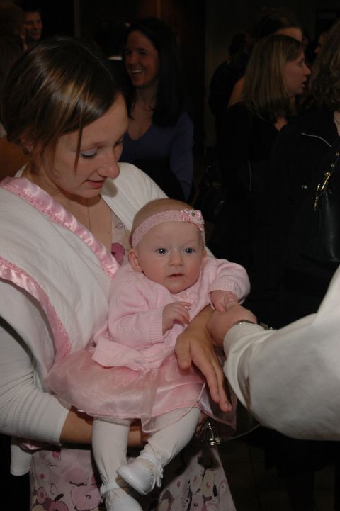 1985 Ford Crown Victoria LTD - A woman holds a baby girl dressed in a pink outfit, possibly at a wedding or special event.