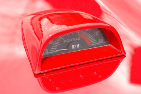 1985 Ford Crown Victoria LTD - A red tachometer is mounted on the hood of a red car, displaying RPMs.