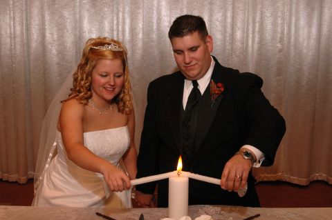 1985 Ford Crown Victoria LTD - A bride and groom participate in a unity candle lighting ceremony during their wedding.