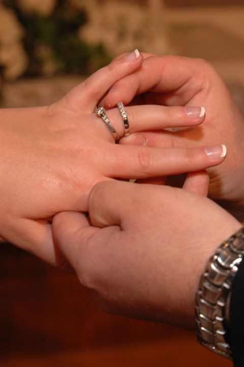 1985 Ford Crown Victoria LTD - A close-up shows hands exchanging wedding rings, symbolizing a union.
