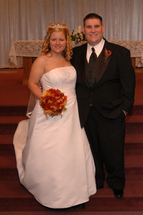 1985 Ford Crown Victoria LTD - A bride and groom stand together on steps in front of an altar.