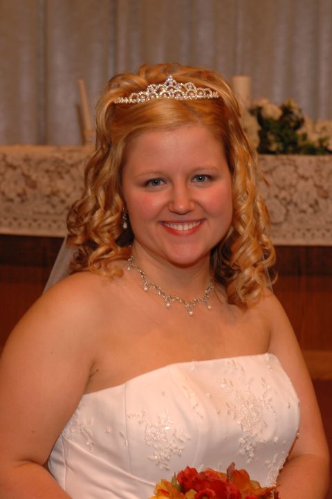 1985 Ford Crown Victoria LTD - A bride smiles for the camera, adorned with a tiara and necklace.