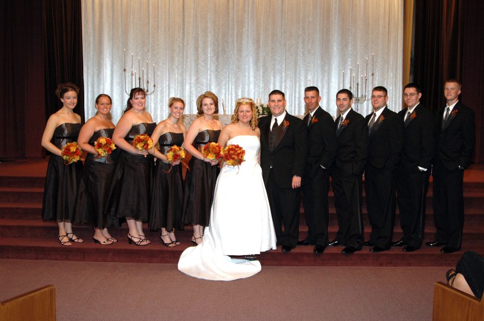 Wedding party posing for a photo in front of a decorated altar