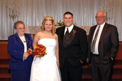 1985 Ford Crown Victoria LTD - A bride and groom stand with family members during a wedding ceremony.