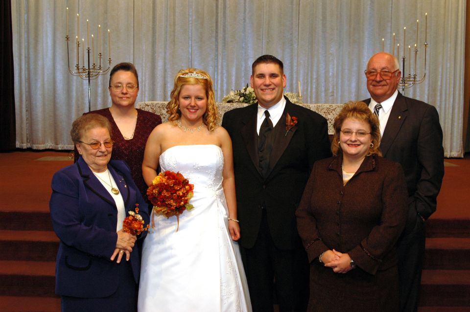 wedding party posing for a photo in front of a curtain