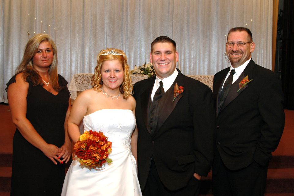 Wedding party posing for a photo in front of a curtained backdrop