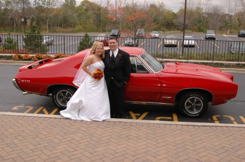 1985 Ford Crown Victoria LTD - A newlywed couple poses with a classic red Pontiac GTO on their wedding day.