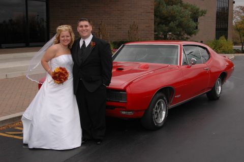 1985 Ford Crown Victoria LTD - A bride and groom pose with a red 1969 Pontiac GTO coupe.