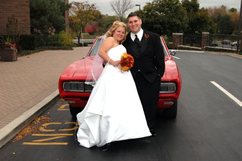 1985 Ford Crown Victoria LTD - A newlywed couple poses for a photo in front of a vintage red automobile.