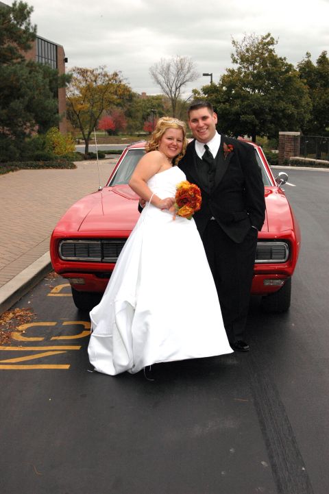 1985 Ford Crown Victoria LTD - A bride and groom pose in front of a red coupe.