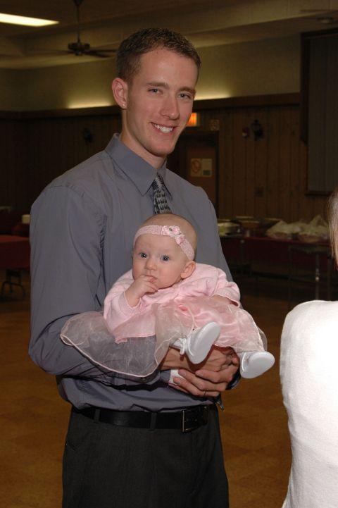1985 Ford Crown Victoria LTD - A man smiles while holding a baby dressed in pink.