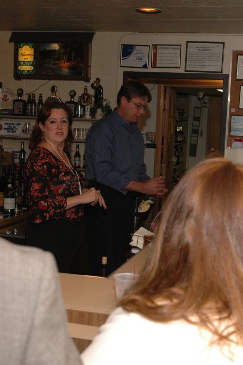 1985 Ford Crown Victoria LTD - Two people work behind a bar while customers are seated in the foreground.