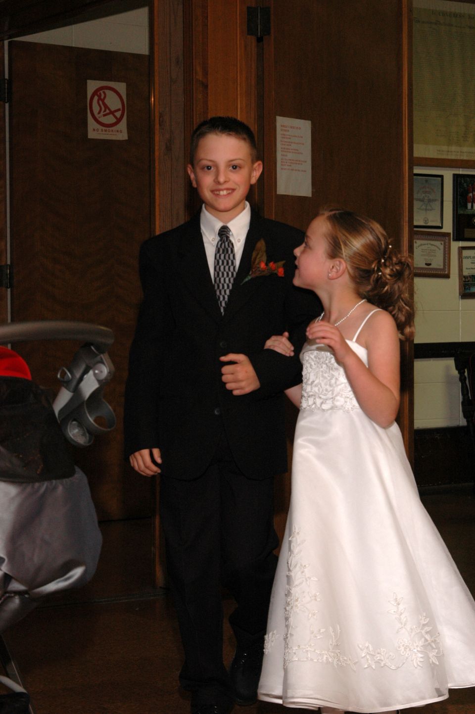 boy in suit and girl in white dress walk together