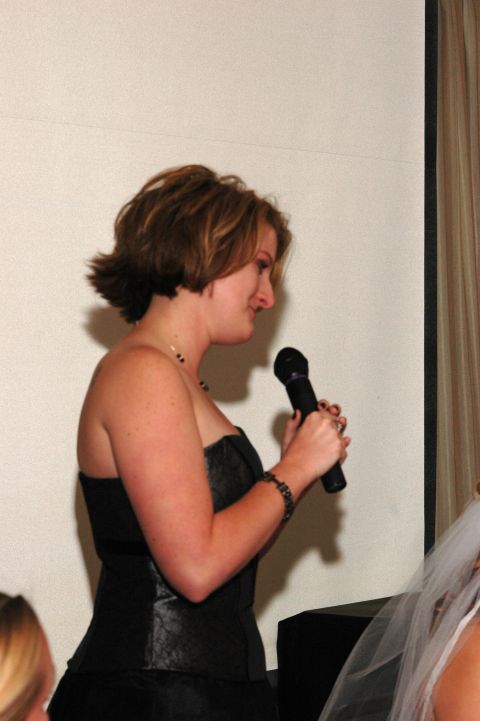 1985 Ford Crown Victoria LTD - A woman speaks into a microphone at an event, possibly a wedding reception.
