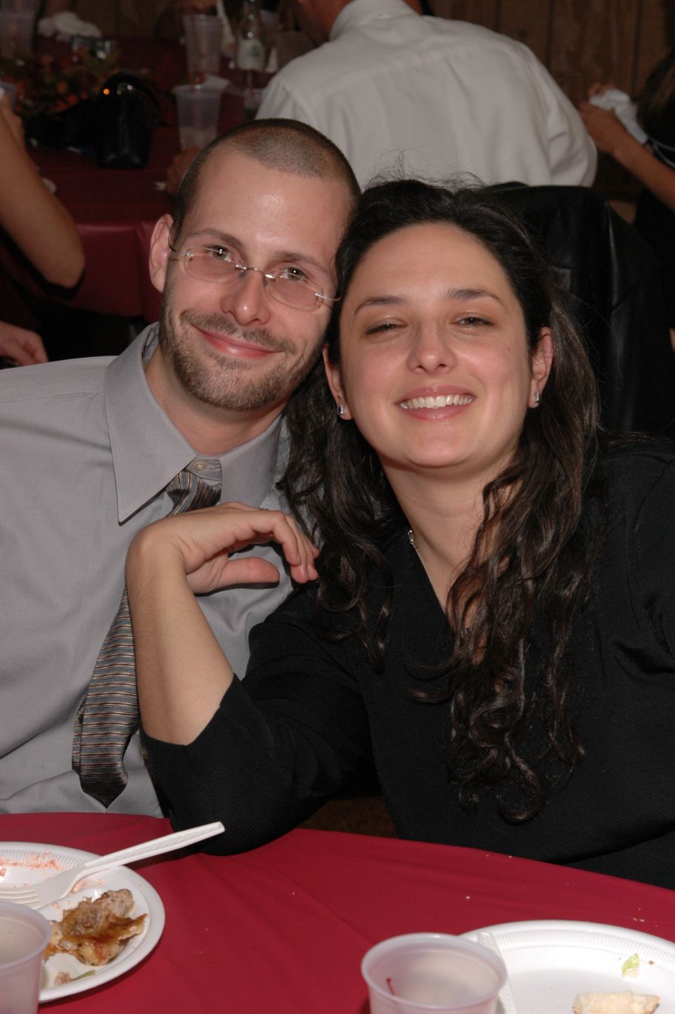 Couple smiling at a table with red tablecloth