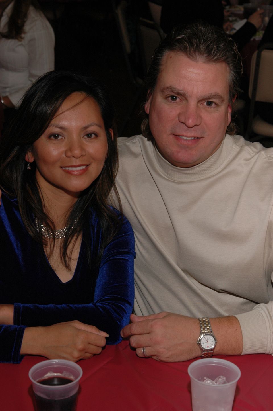Couple posing for a photo at a table with drinks